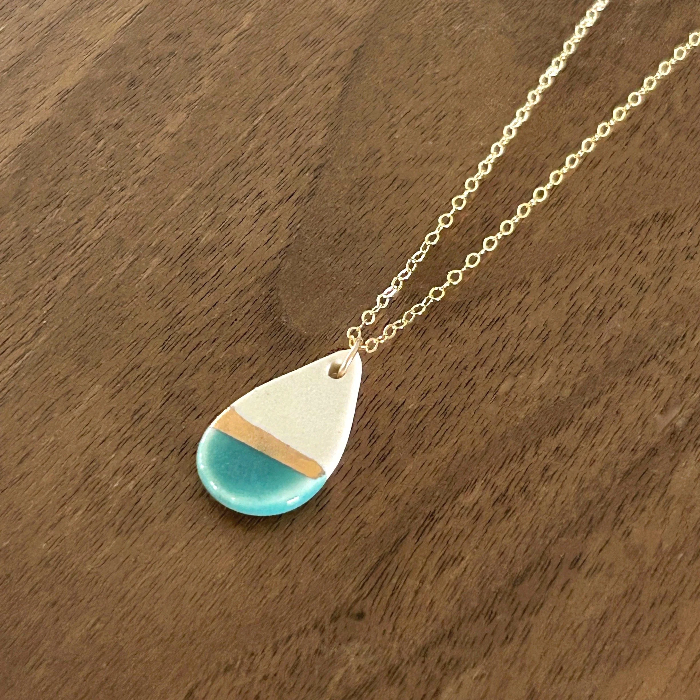 ZOE%CC%88+COMINGS+teardrop+necklace%2C+teal%3Agold+line+a+wdbkg.jpg