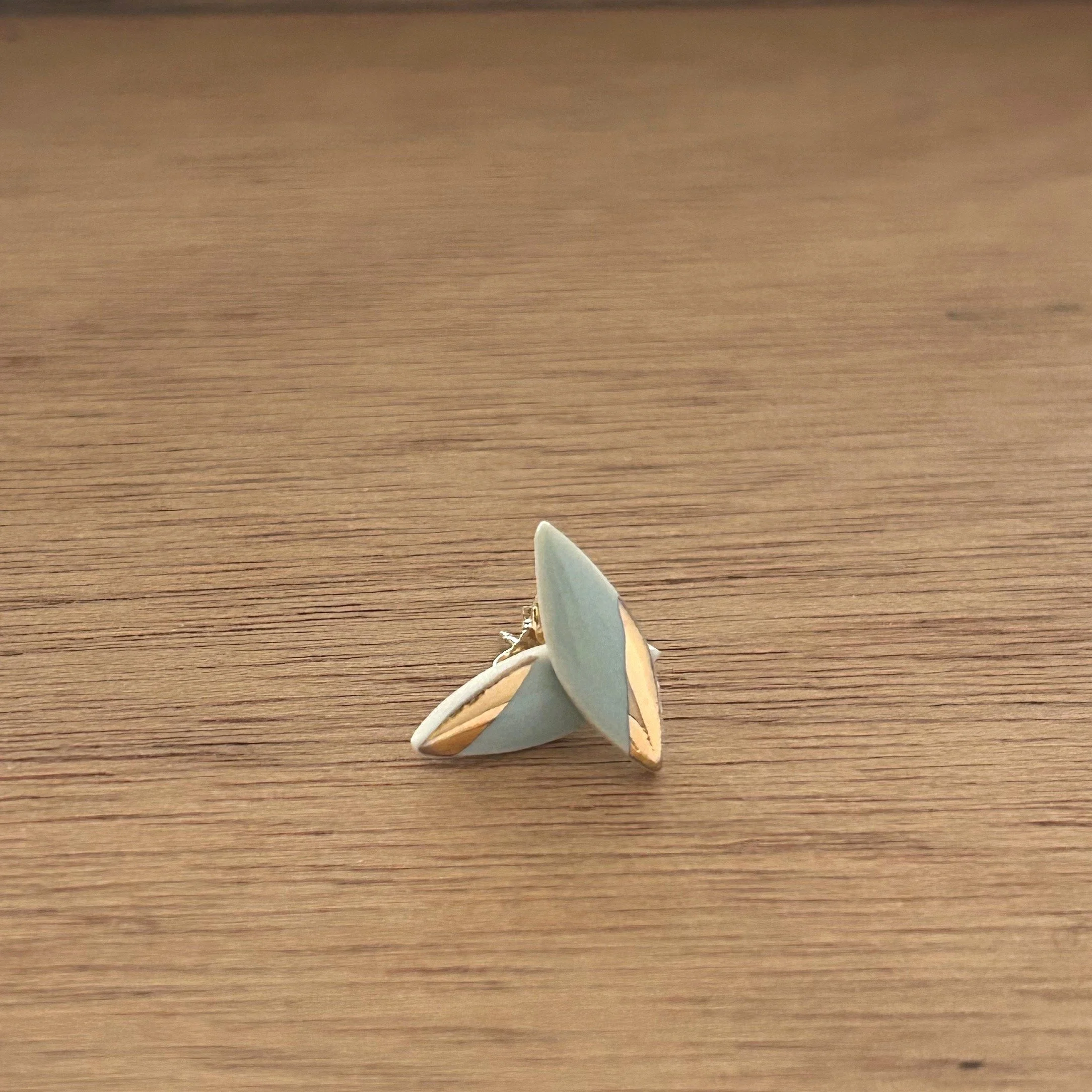 ZOE%CC%88+COMINGS+tiny+leaf+studs+pale+blue%3Agold+angle%2C+wdbkg.jpg