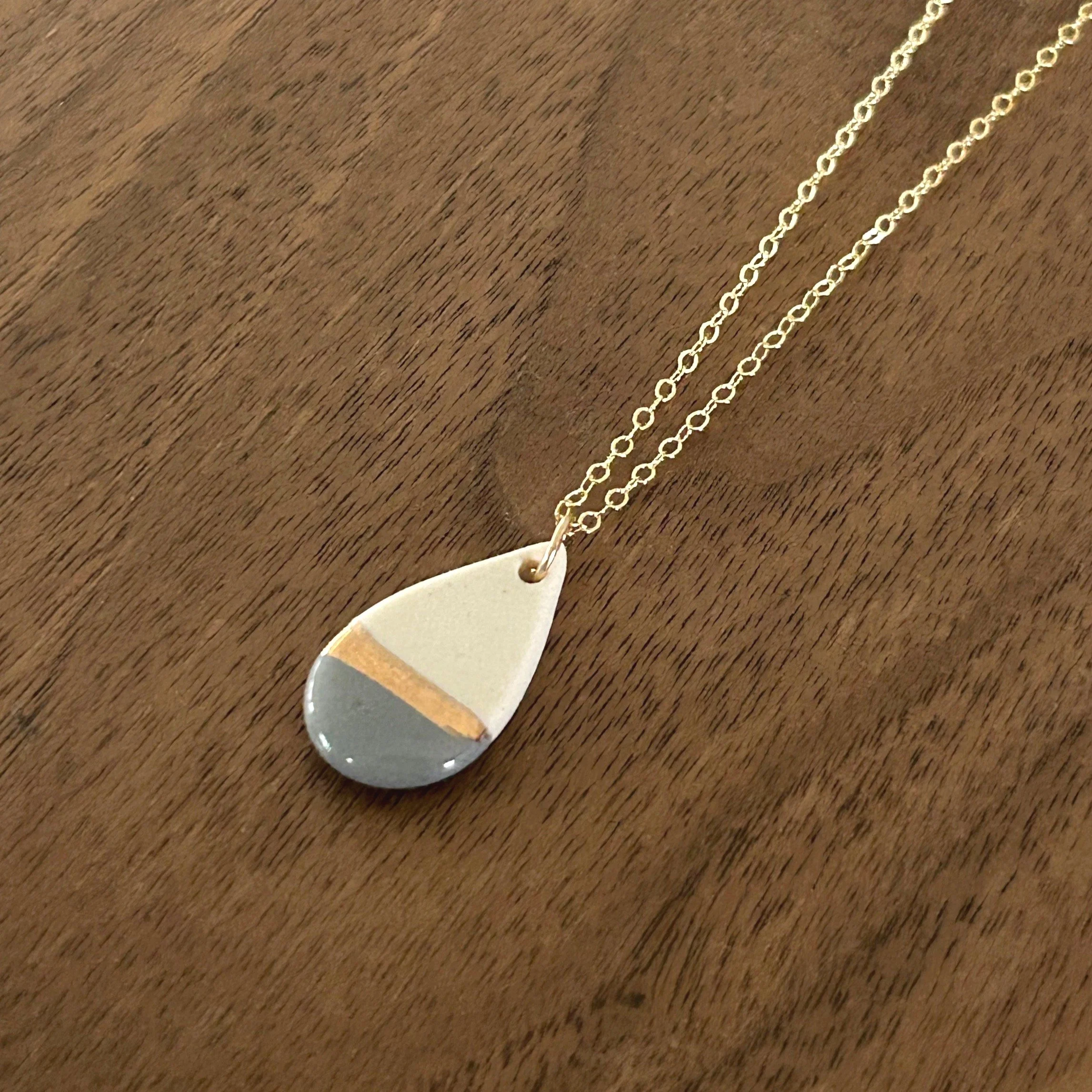 ZOE%CC%88+COMINGS+teardrop+necklace%2C+dark+grey%3Agold+line+a+wdbkg.jpg