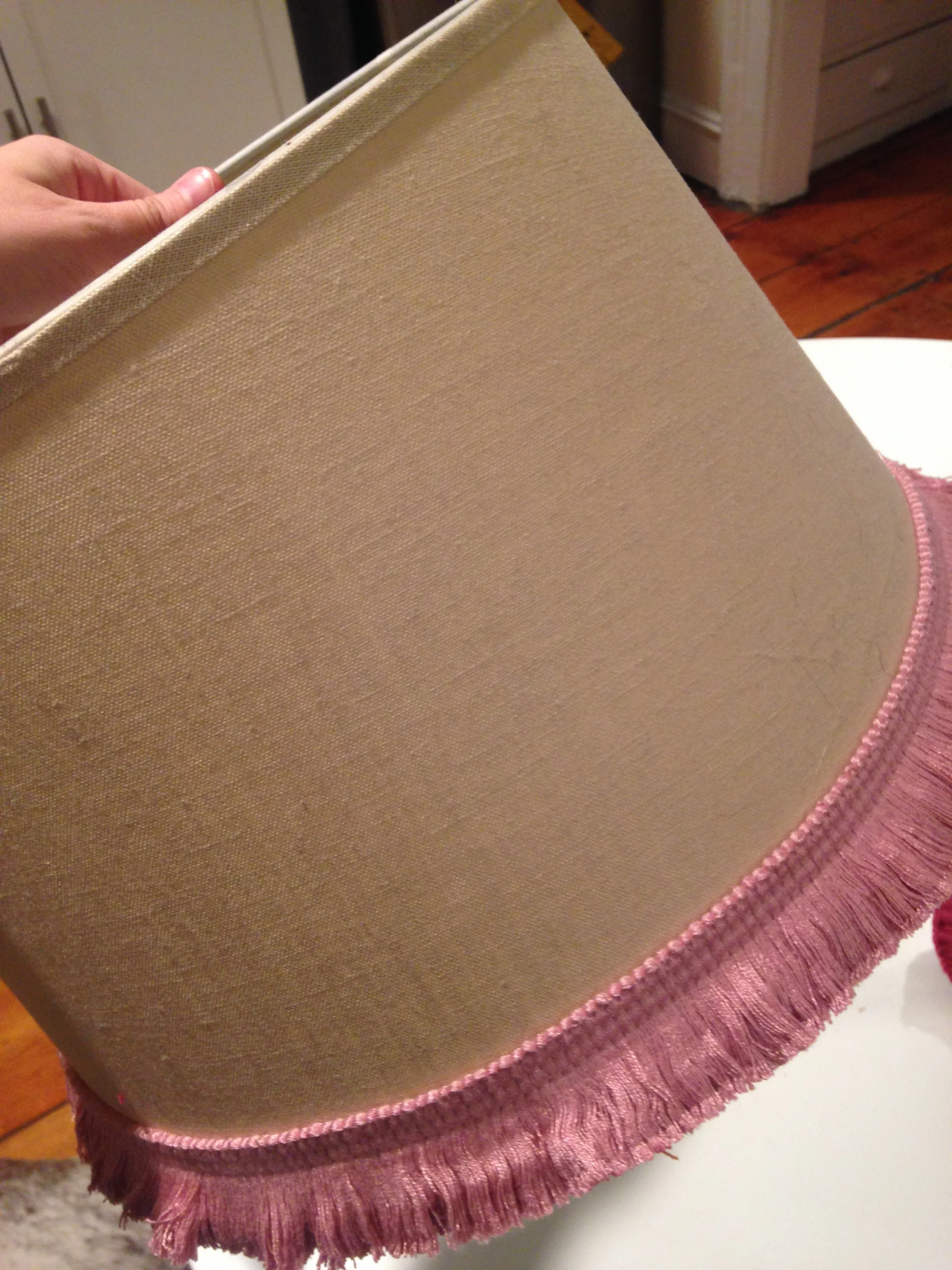 Using your hot glue gun, pick your starting point (I usually go for a seam) and slowly apply the hot glue to the top of the trim and press into place. Continue around circumference of shade. Repeat with each color.