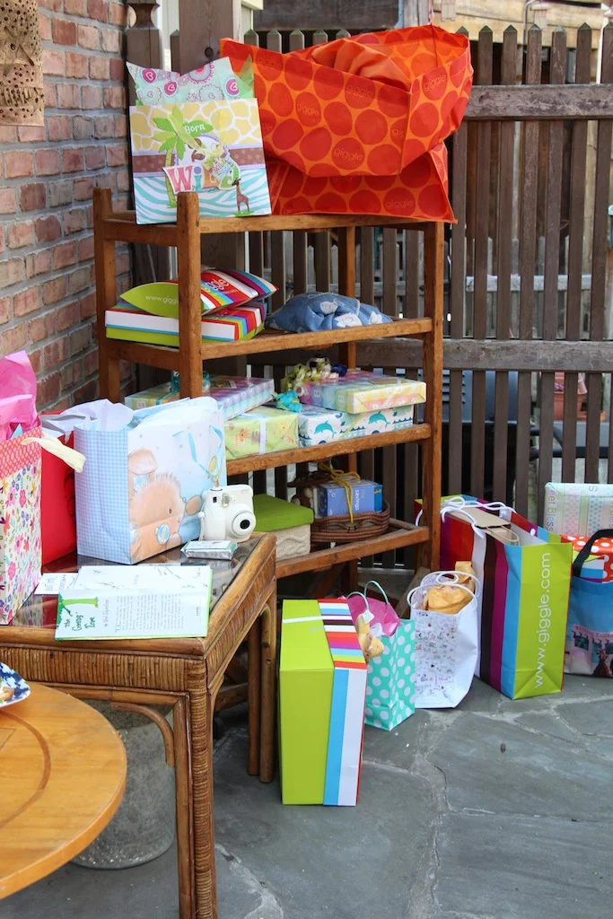Use what you have! Rather then placing all of the shower gifts on the ground, or buying a table for them to sit on, I rolled the bakers rack from our kitchen (the piece that normally held some of our dishes) outside and arranged the gifts. This made for a festive gift display that added to the outdoor party vibe. 