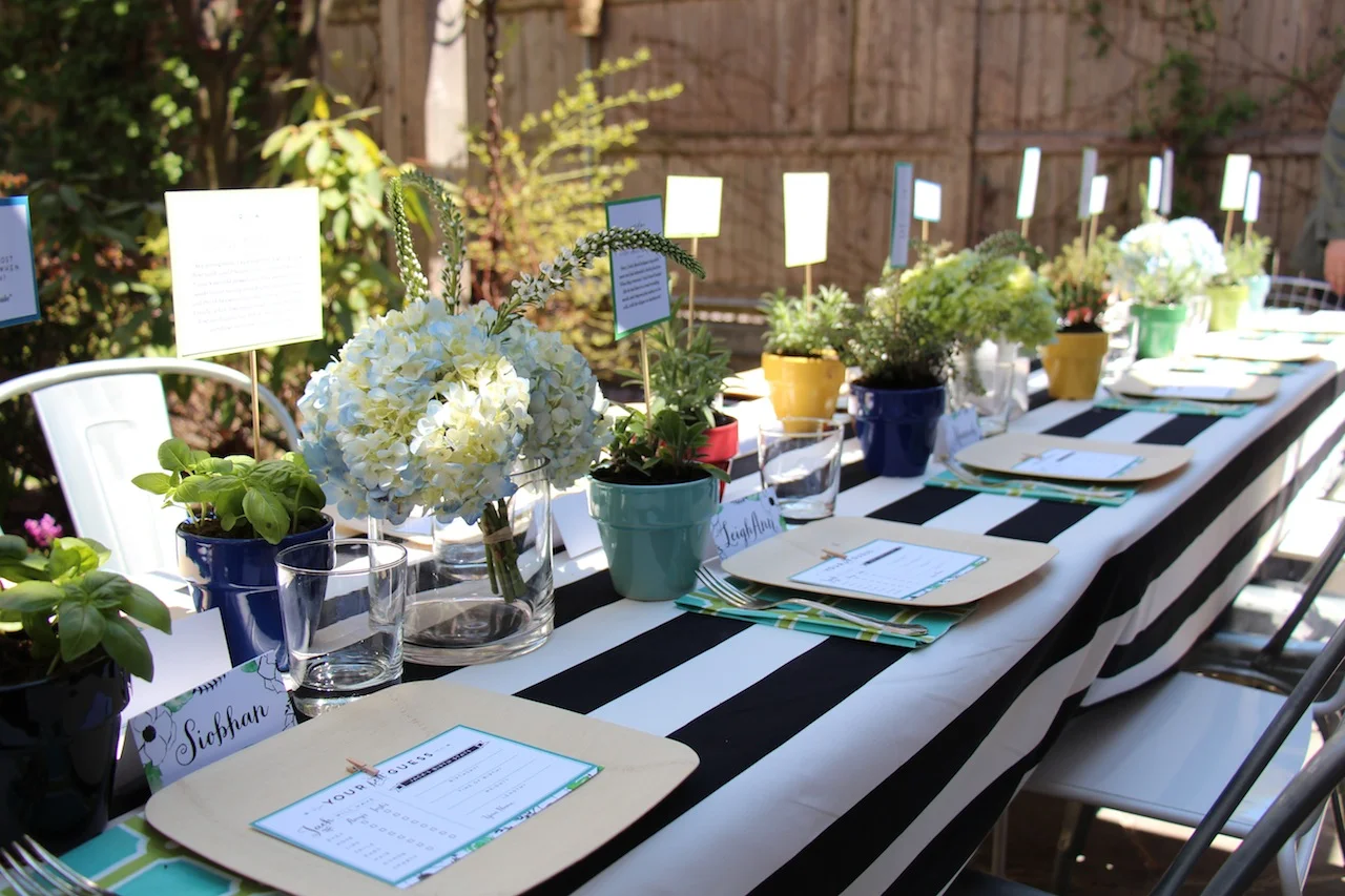 DIY Potted Herbs = Centerpieces & Party Favors I took my centerpiece cue's from the backyard and decided to use herbs as table decor. We picked up a variety of herbs from the hardware store down the street, quickly potted them in colorful containers (minutes before the guests arrived) and placed them in front of each table setting. Then we used skewers and some of the baby Q & A's LeighAnn designed and printed and stuck them in each pot. Once the party was over, we encouraged each party goer to take one as a party favor. Viola, dual purposed table decor! 
