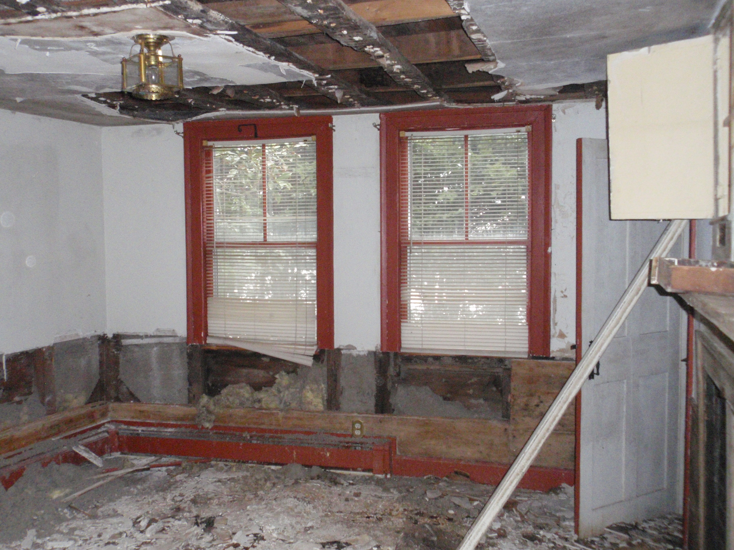  The historic kitchen has seen the most damage in the house. Original paneling has been pulled from the walls and some of the ceiling plaster has been taken down. 