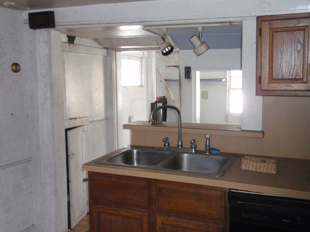 The rear of the ell is a mudroom space, with a pantry just behind the sink, to the right. 