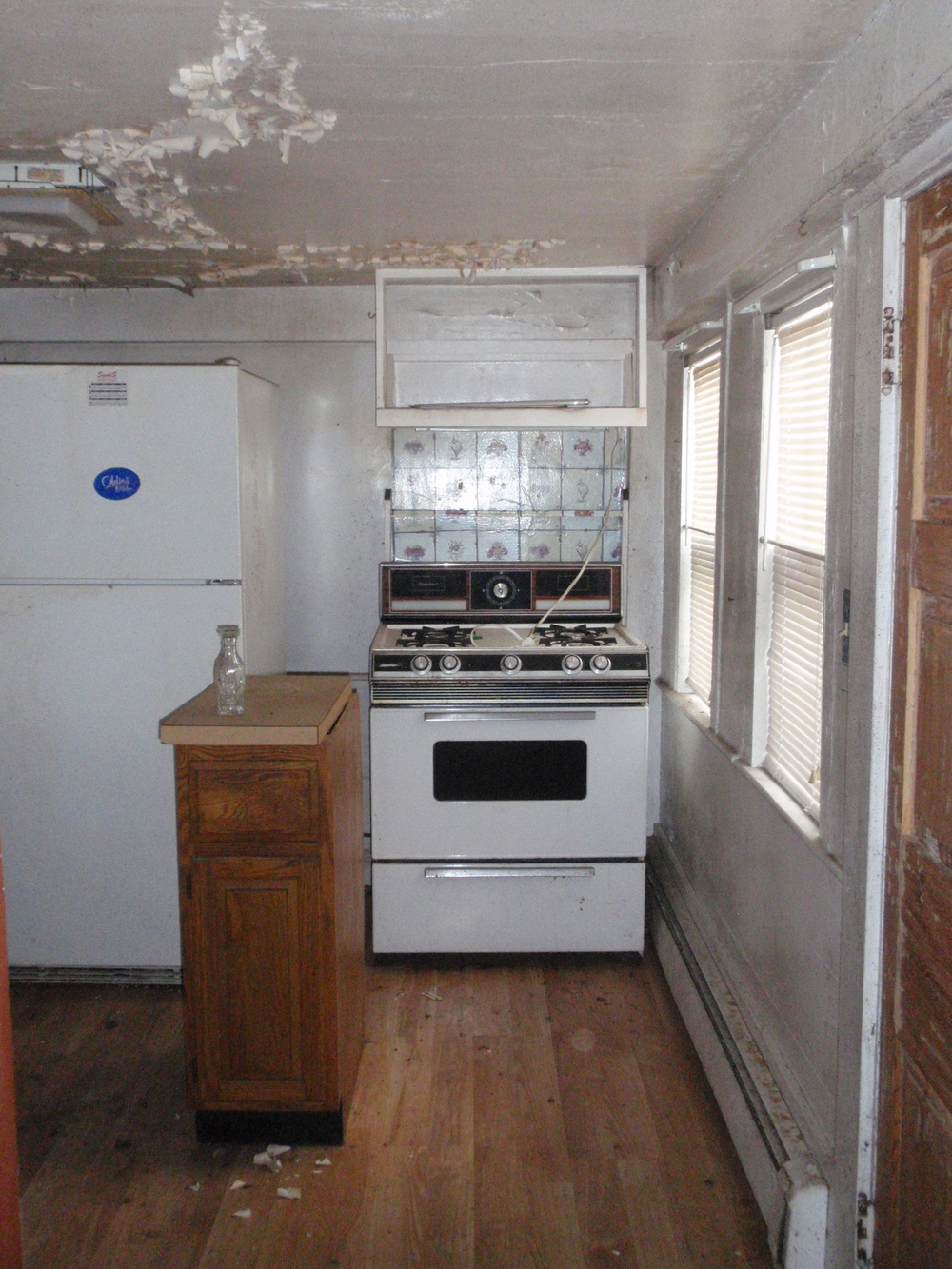  The kitchen ell, dating to the late 19th century, has modern updates such as new flooring and appliances, but retains its original two-over-one window sash.   