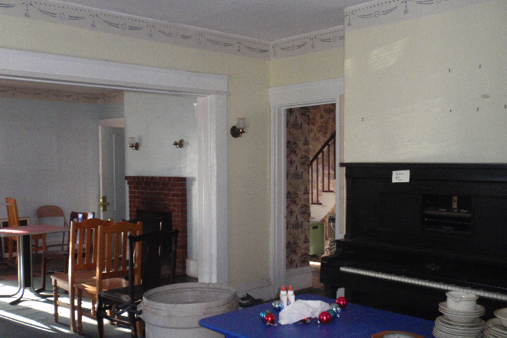  The wall between the two front rooms was removed at some point, to open the space up. The fireplace in the rear room has been removed, while the one in the front room has a modern brick surround. 
