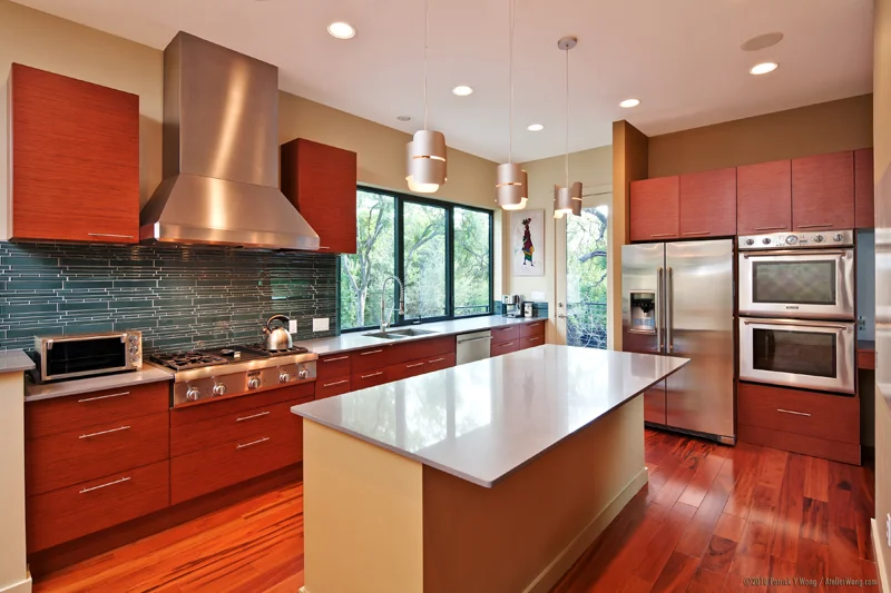 A contemporary kitchen by Element 5 Architecture features flush cabinetry, built-in appliances and views of the landscape.