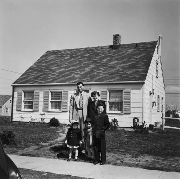 A family of 5 outside their newly purchased home in Levittown, NY. Now this house sells for $500,000. 