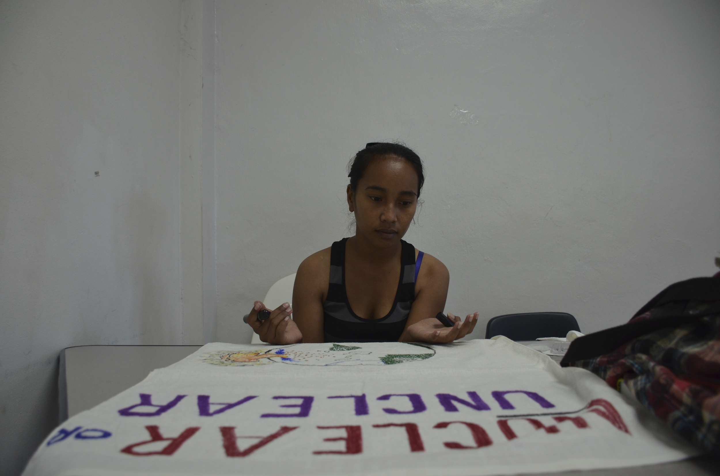  Suewellynn Johannes, a student at the College of the Marshall Islands,&nbsp;prepares a banner for Nuclear Victims Remembrance Day. 