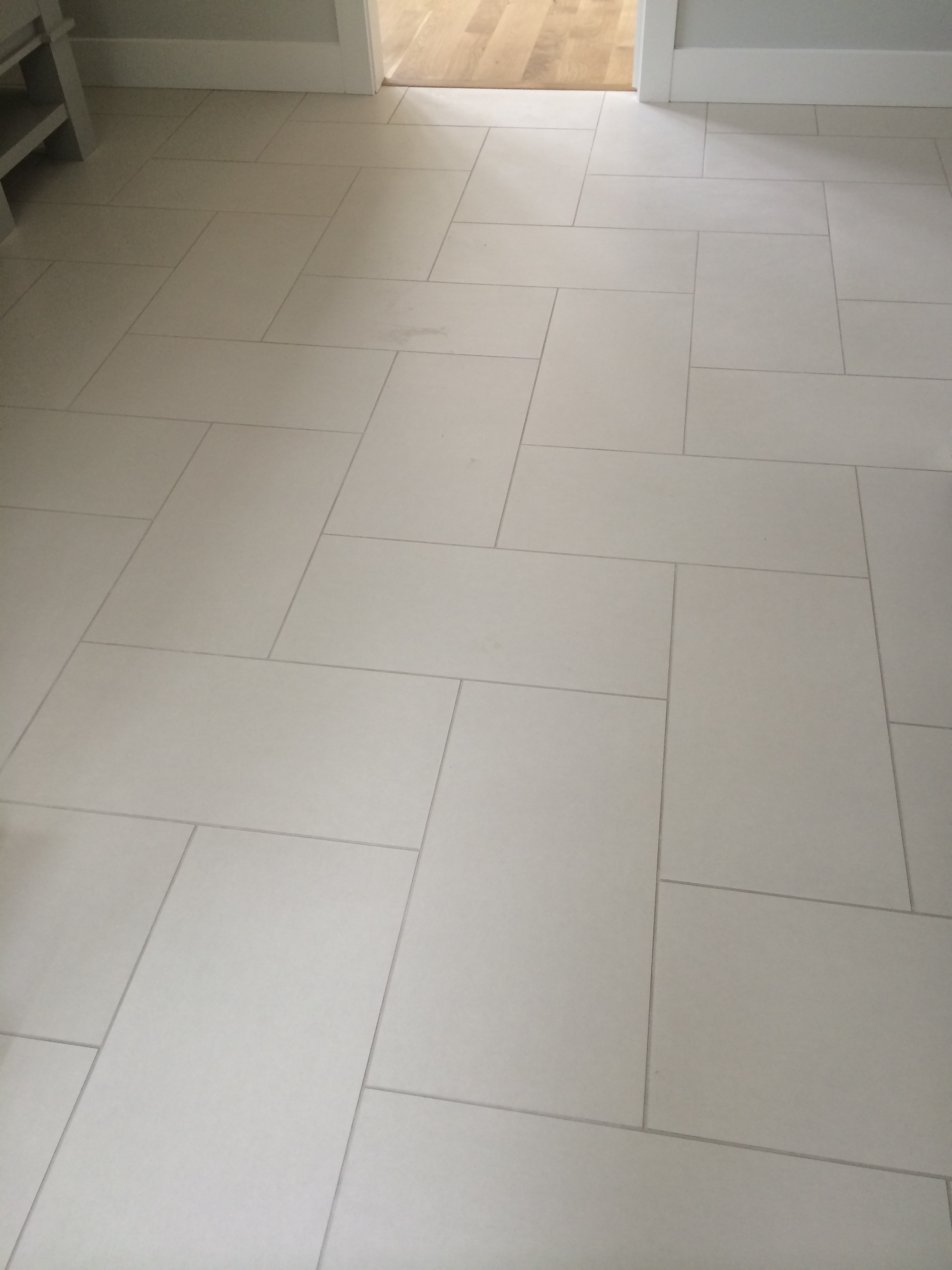 This master bathroom shows a 12" x 24" neutral tile, with light gray grout, installed in a herringbone pattern.