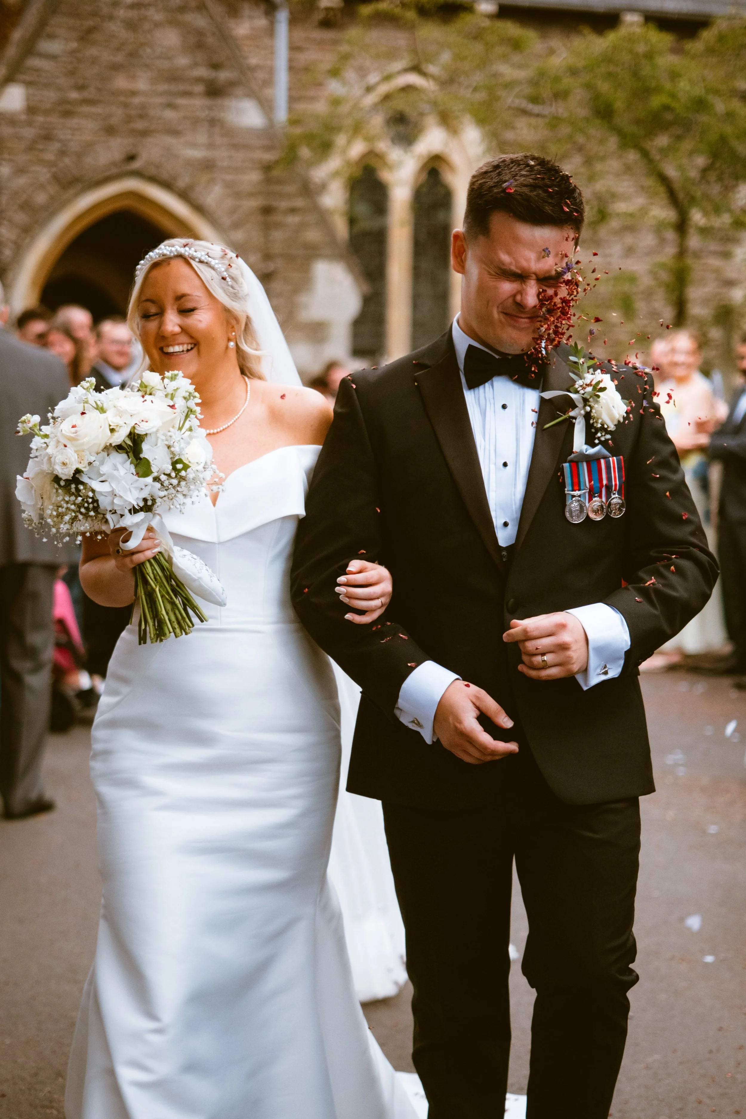 Bride and groom having confetti thrown at them
