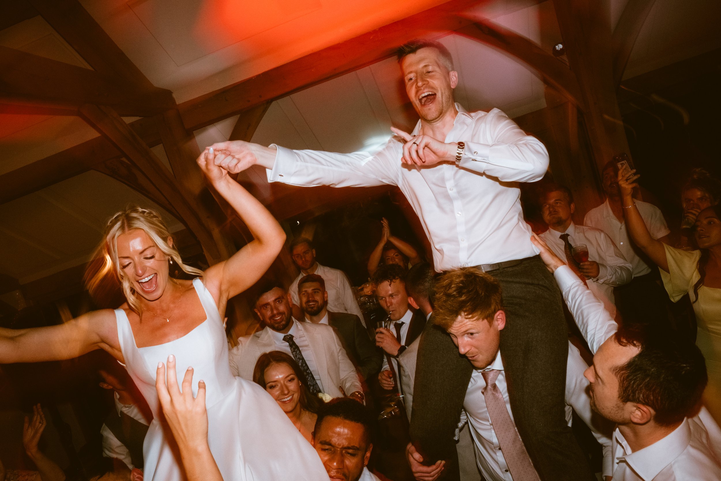 Bride and wedding guests dancing together on a packed dance floor at Brinsop Court