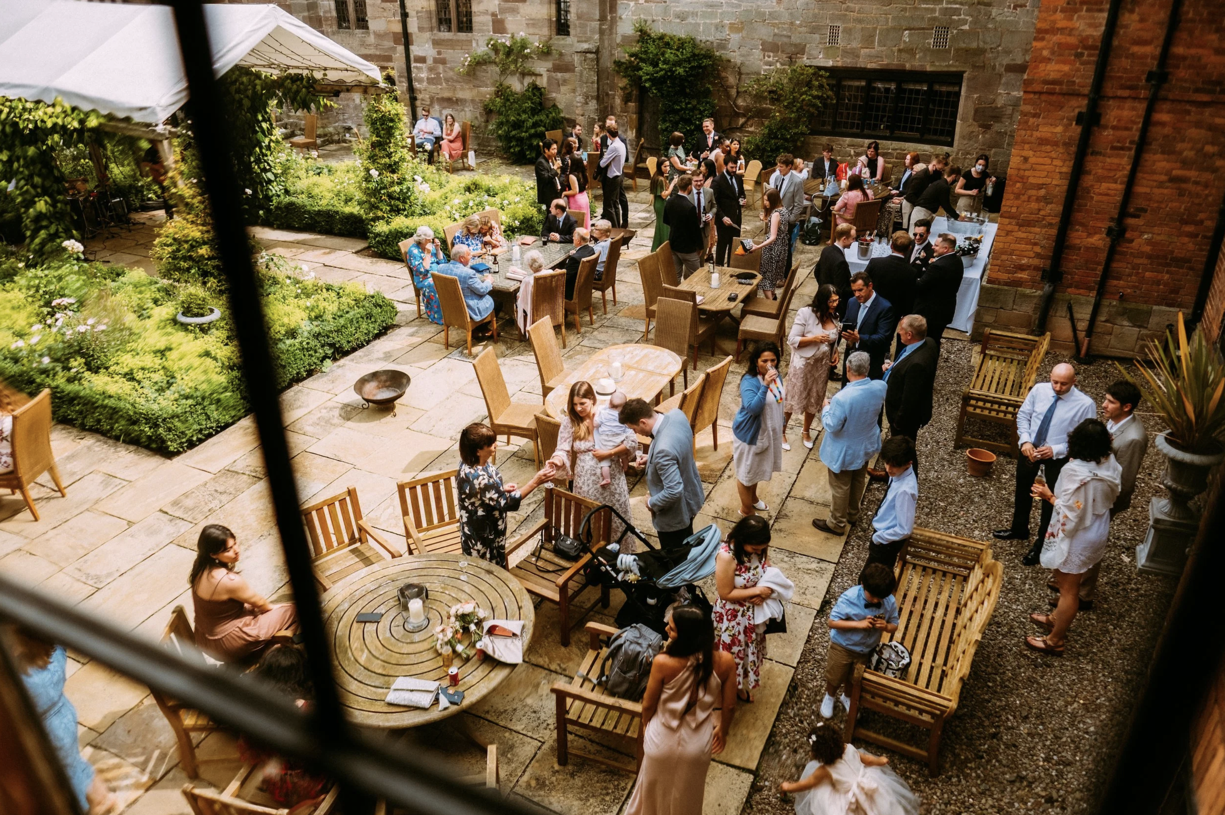 Wedding guests enjoying the drinks reception in the Brinsop Court courtyard