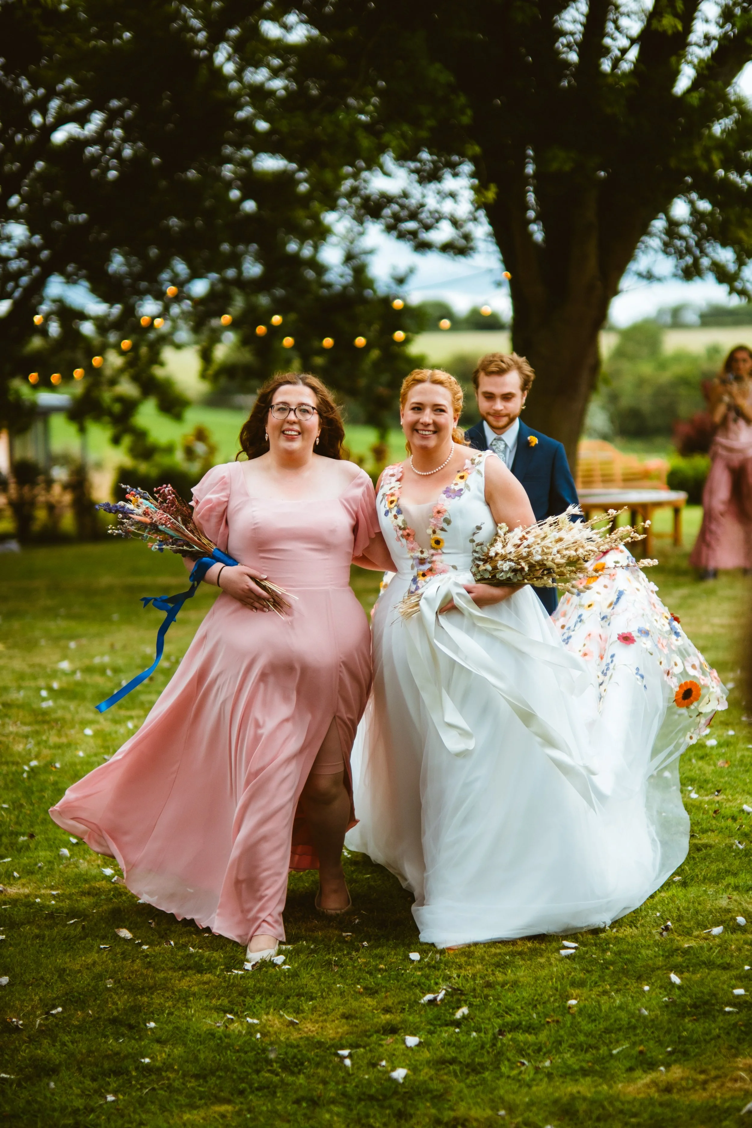 Happy bride and sister walking down the aisle