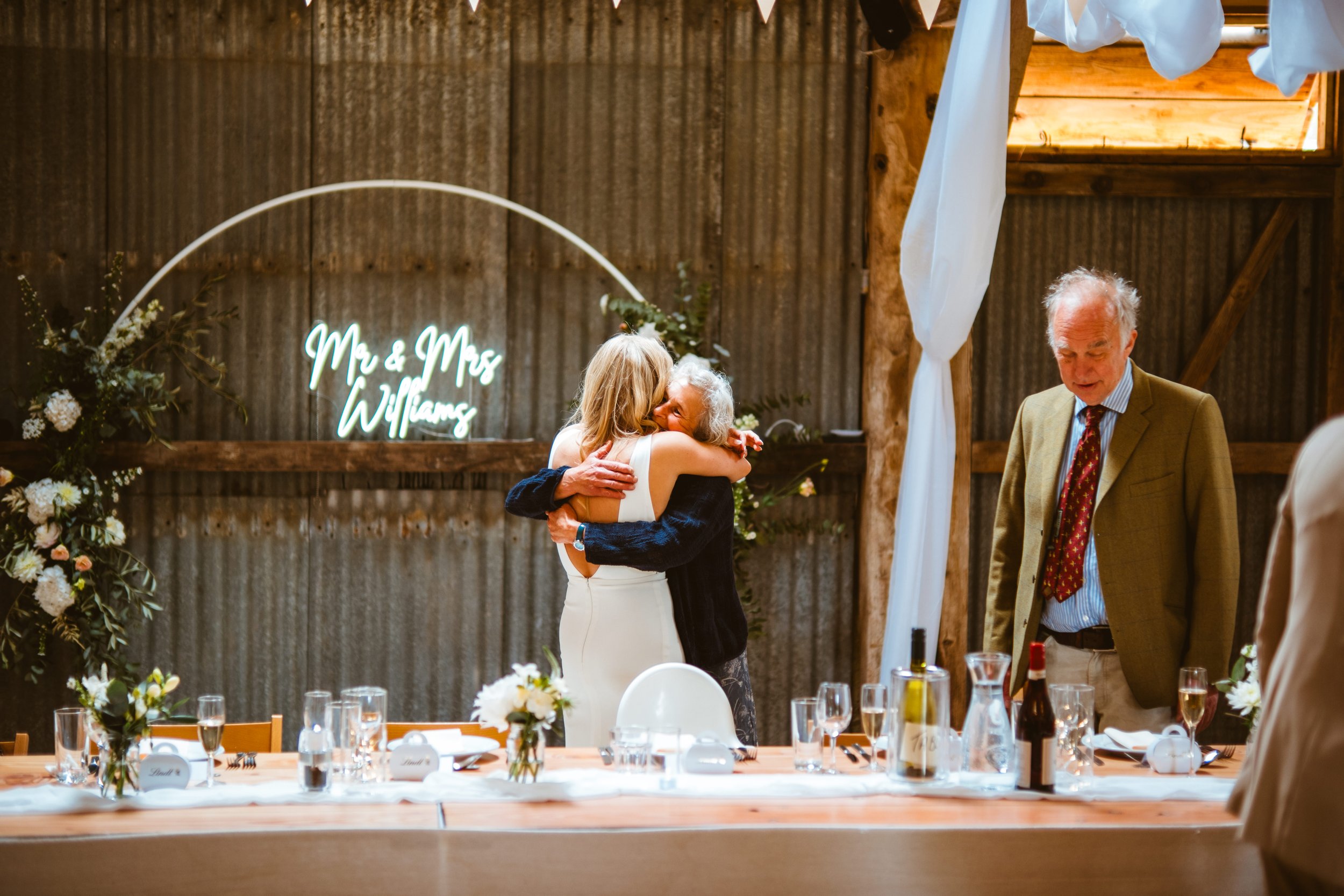 Bride and mother hugging at The Haybarn