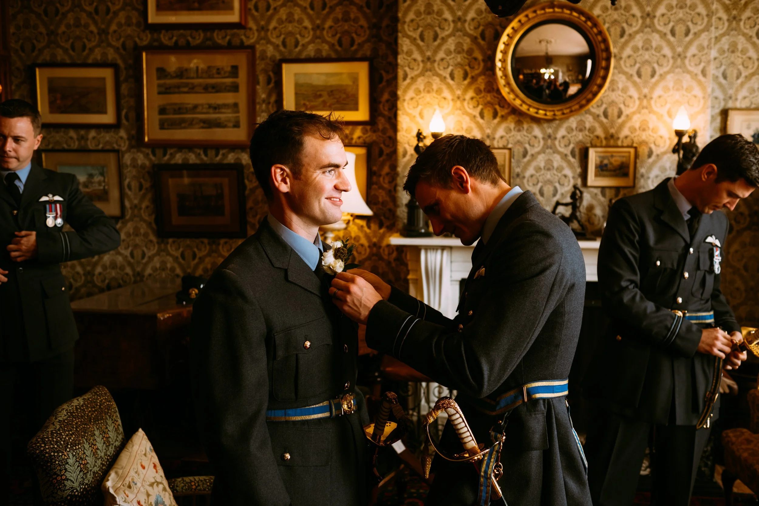 Groom in a military uniform having his buttonhole attached