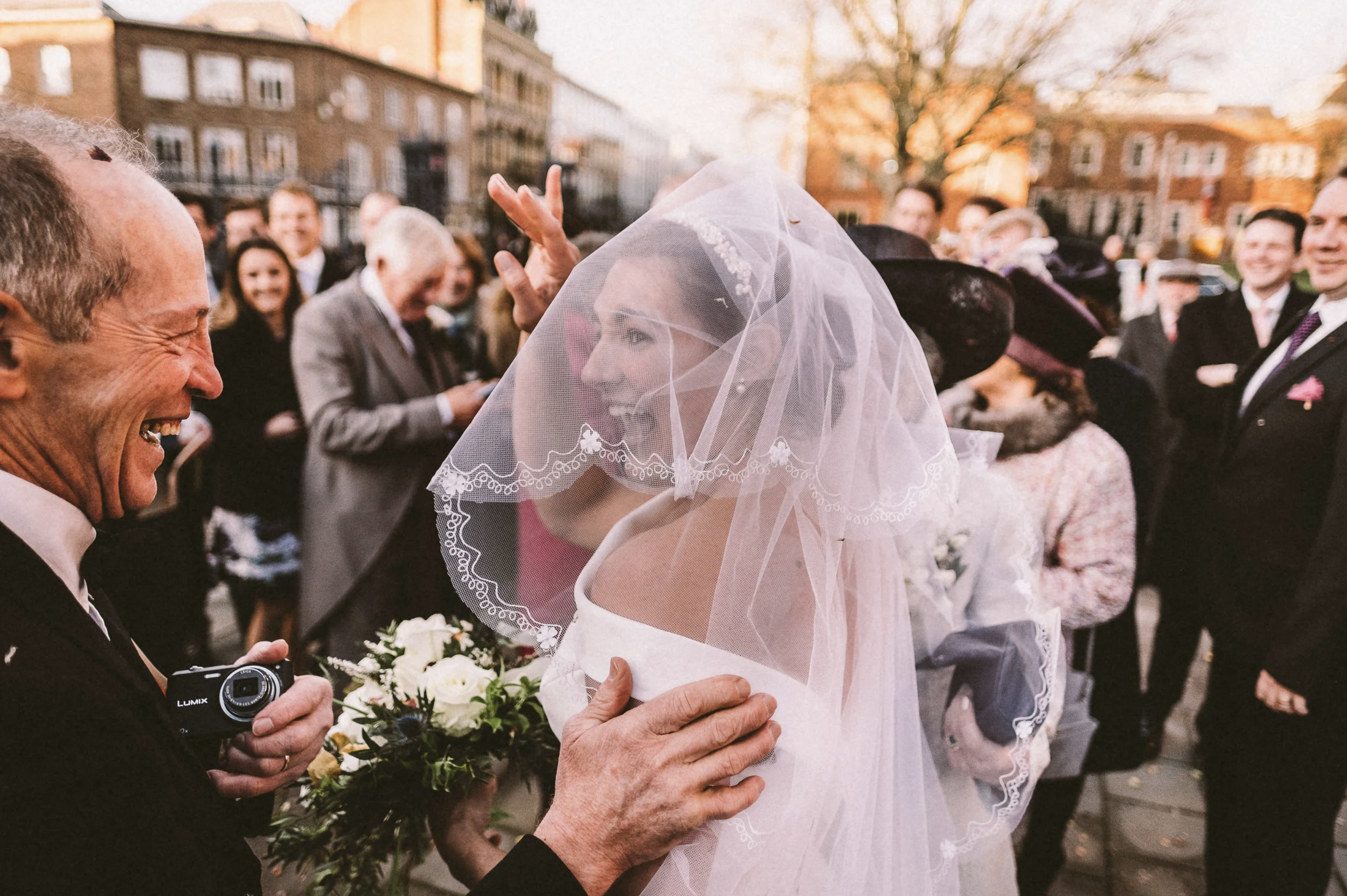 Bride laughing with her dad beneath her veil after the wedding ceremony at Hereford Cathedral