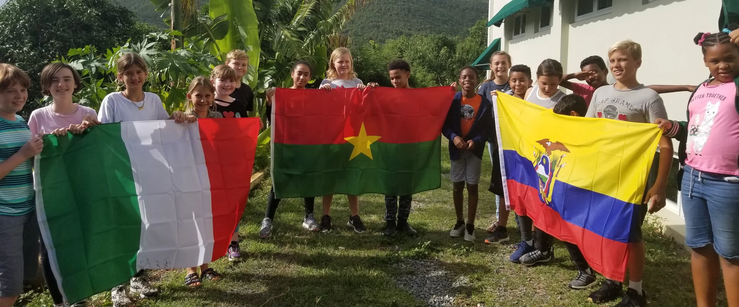 MMUN Students holding the flags of the countries to be represented. Left to right: Italy, Burkina Faso, Ecuador.