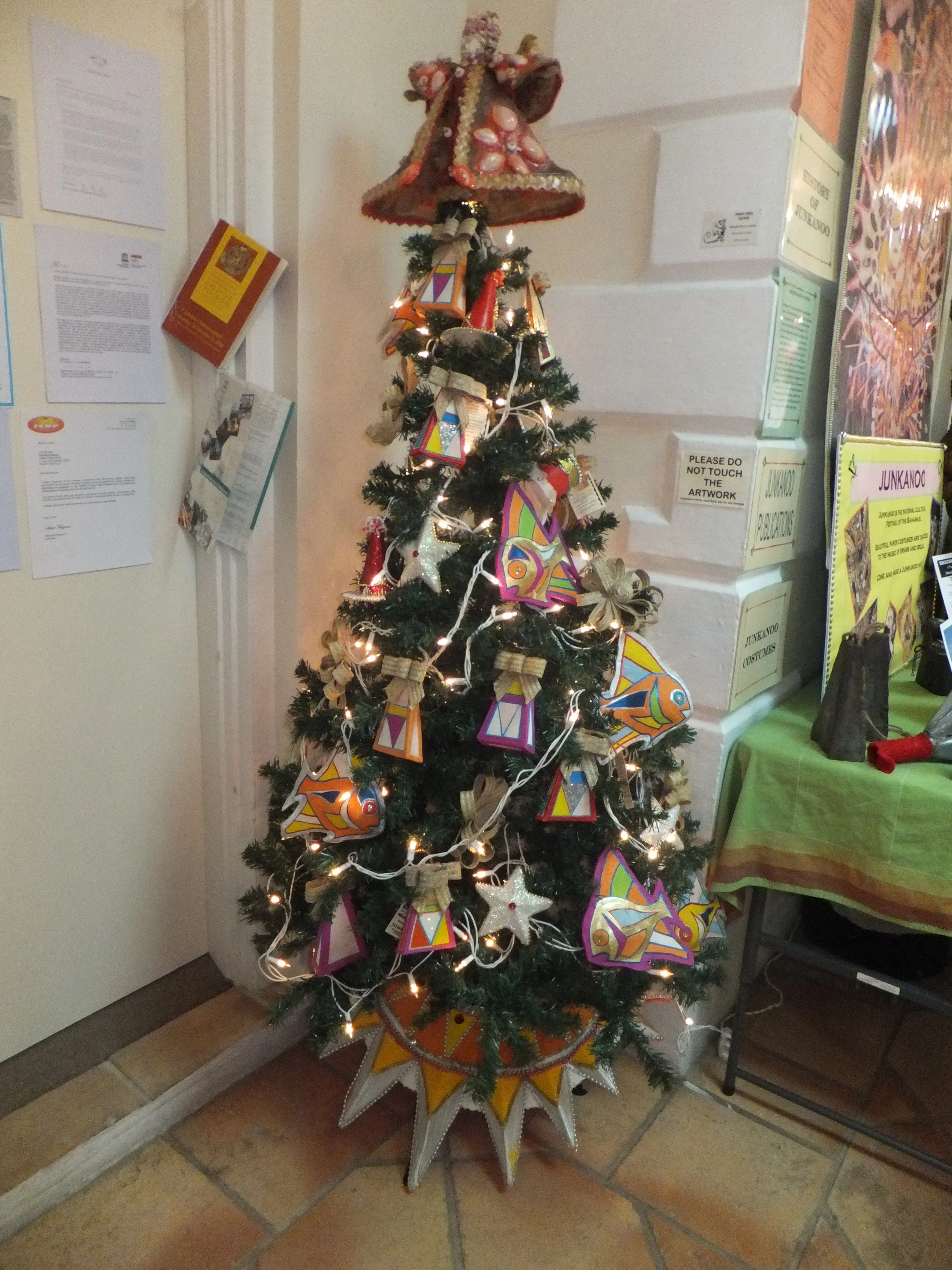 A uniquely Bahamian Christmas tree decorated with hand made junkanoo ornaments and a straw and shell studded tree topper angel