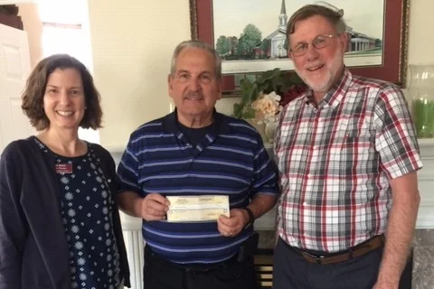 Sarah Harte (l) & Charles Warner (r) from Faith Community Homes present Bill Reidinger, Chair Local/Global Outreach (c)