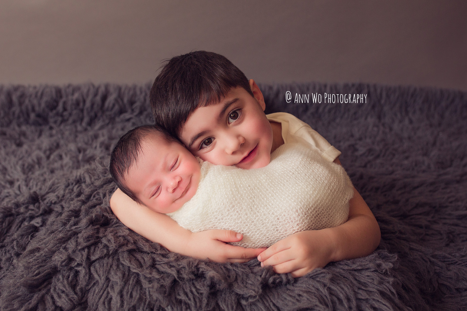 brother and newborn baby sister cuddle adorable flokati ann wo london