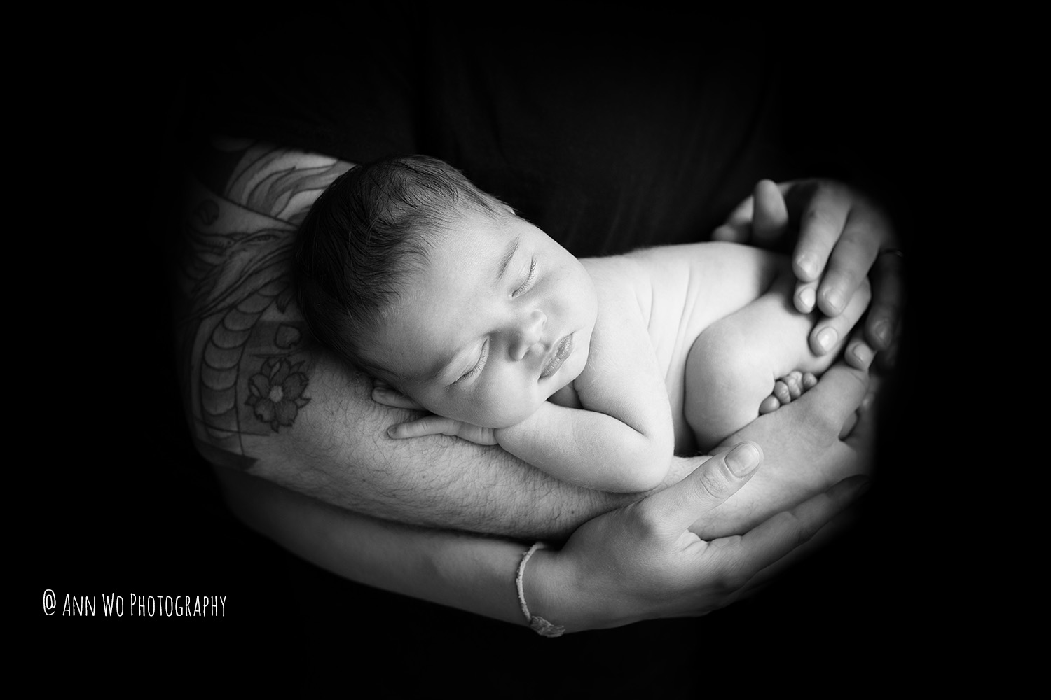 newborn photography in London - baby sleeping in dad's arms