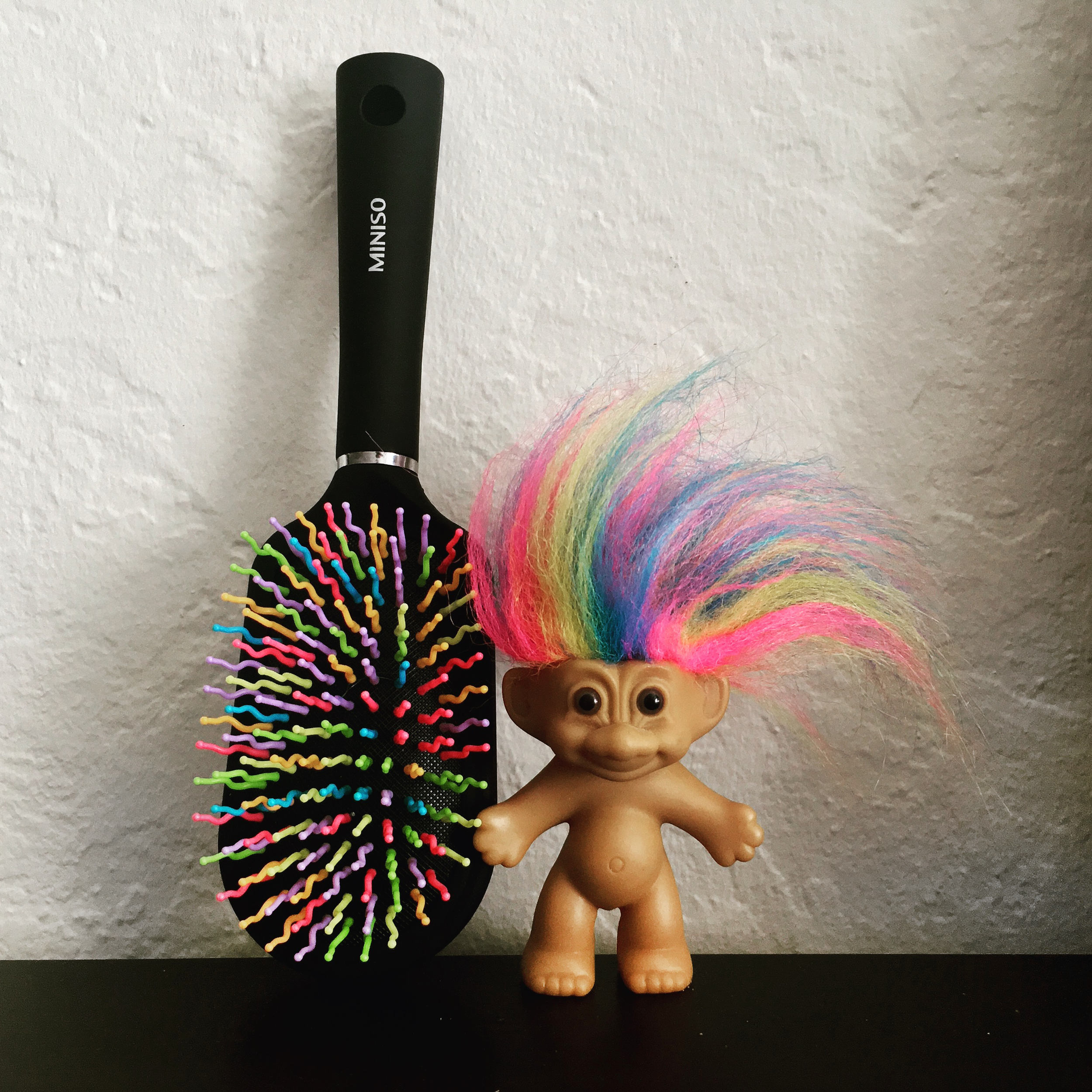 Similtude no. 2: hairbrush with multicolored teeth and a troll doll with multicolored hair.