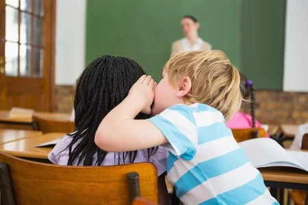child whispering in class.jpg