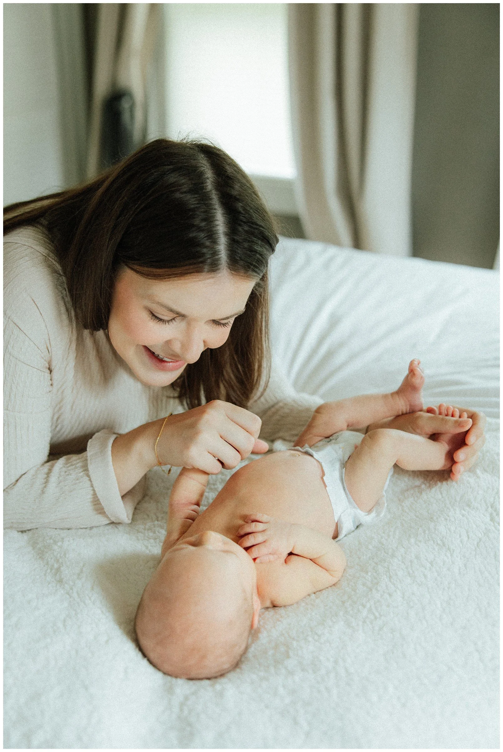 mom-smiling-at-newborn-on-bed.jpg