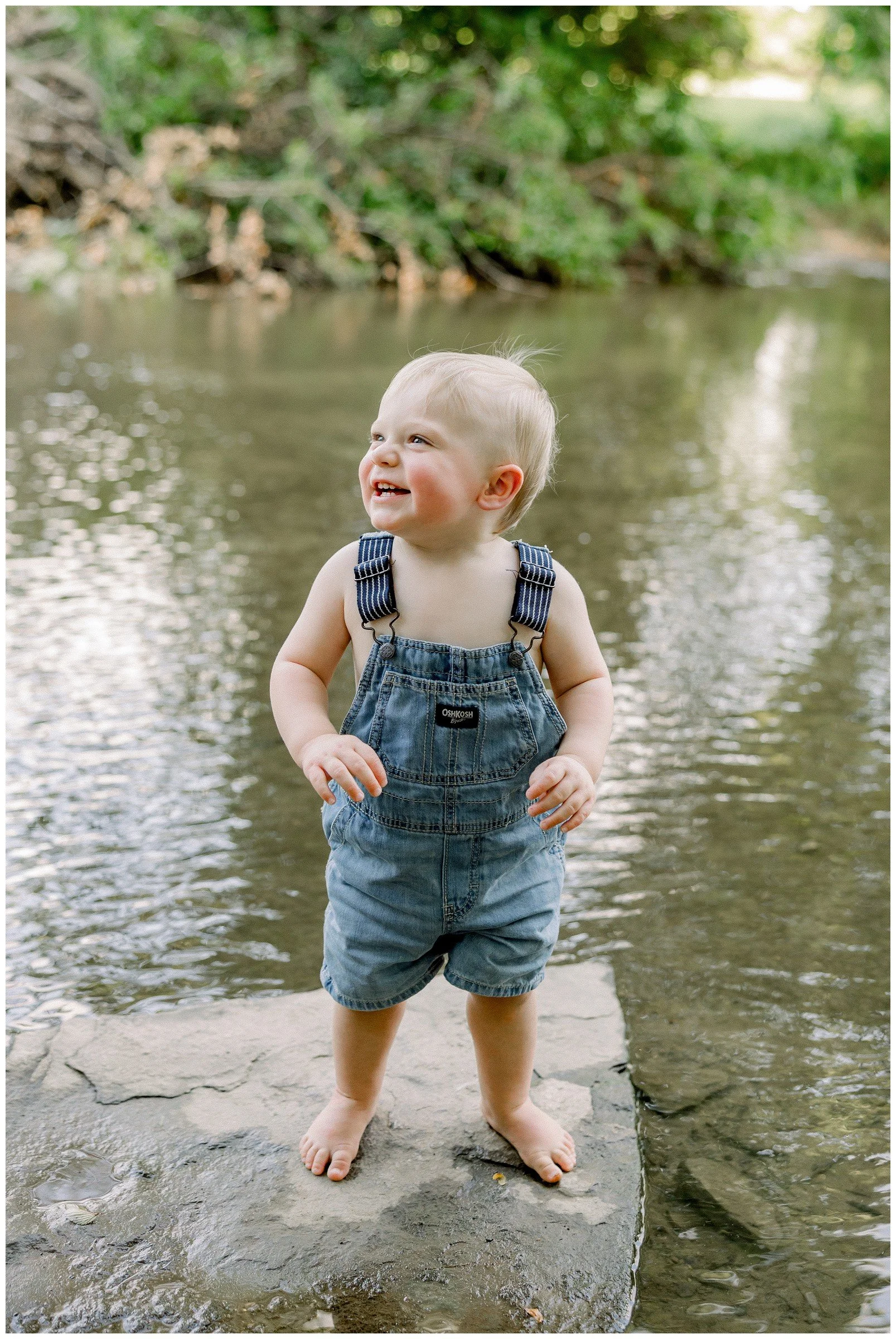 one-year-old-boy-by-creek-overalls.jpg