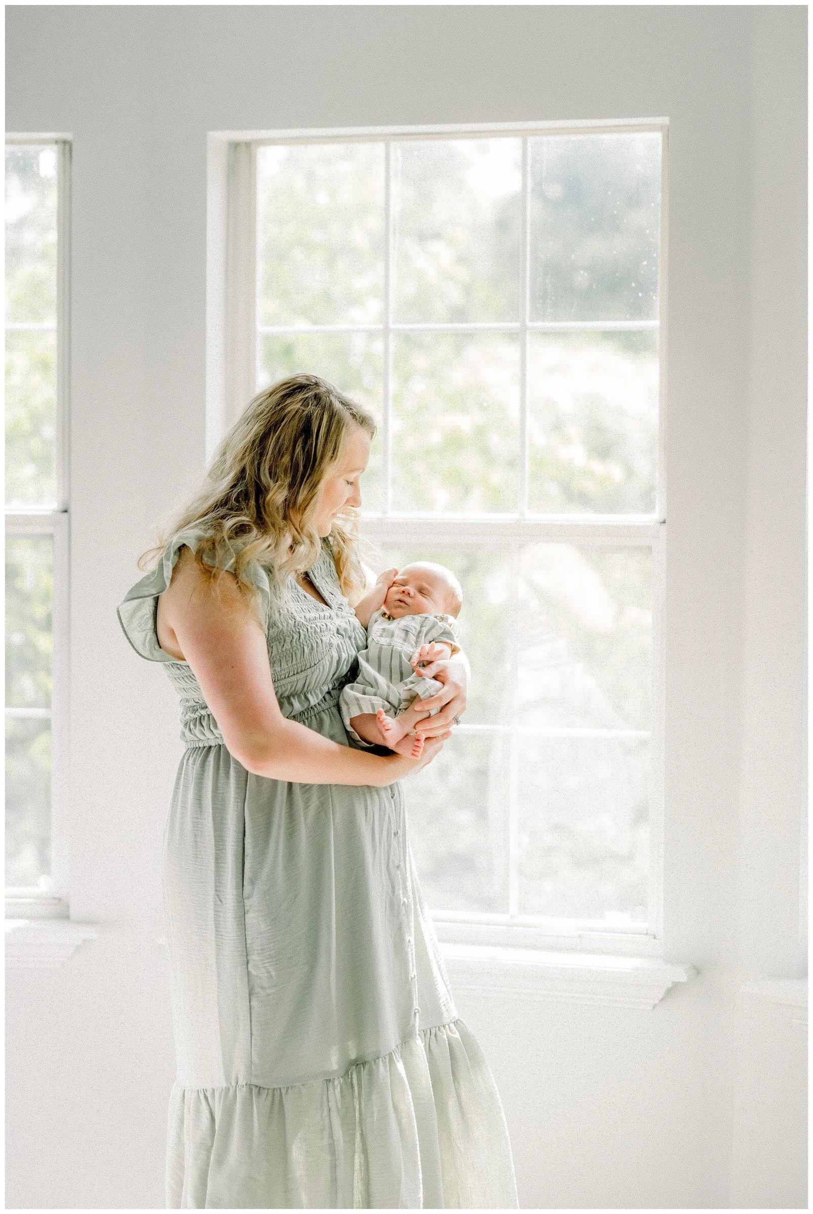 new-mom-holding-newborn-window.jpg
