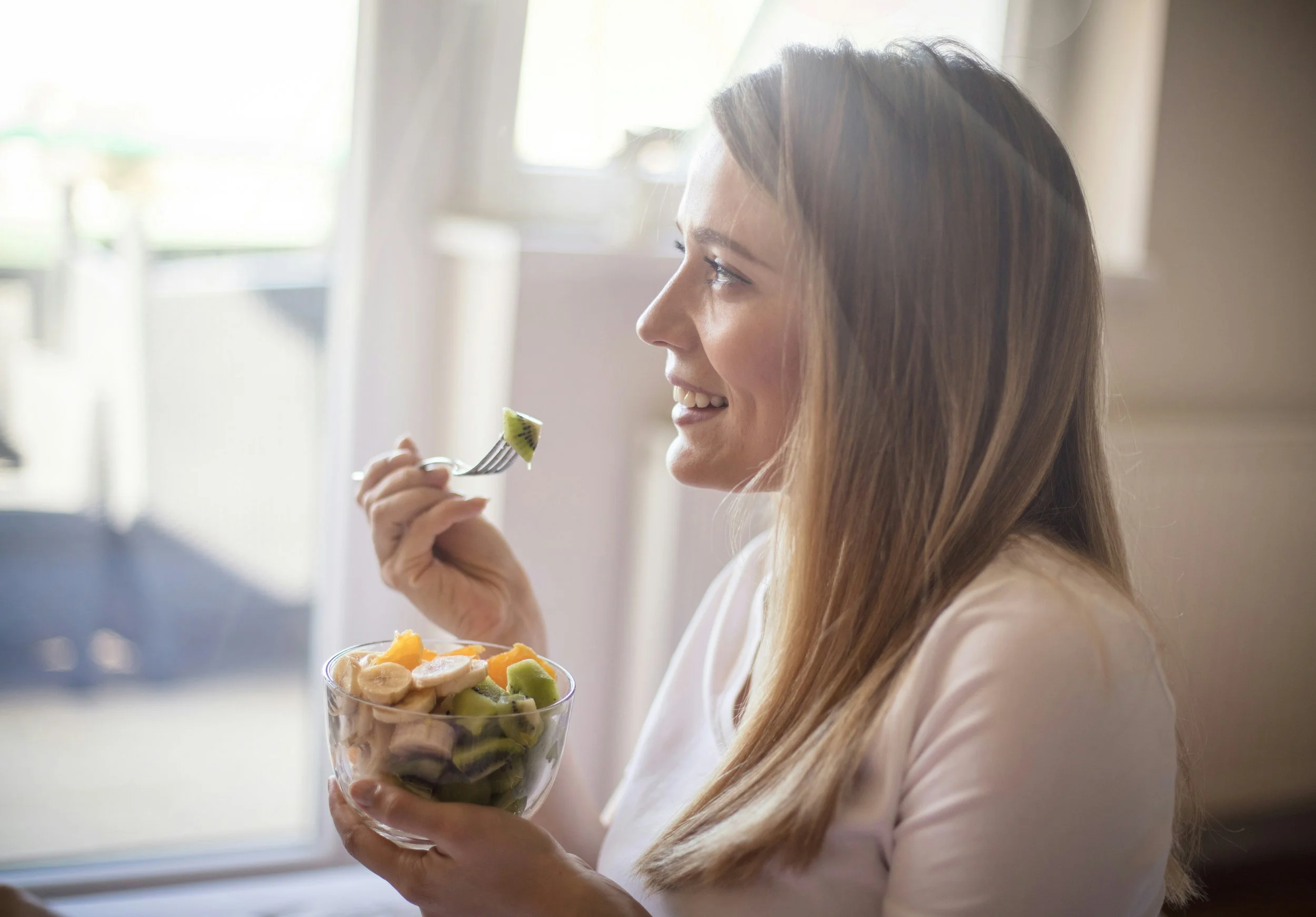 Woman enjoying snack, comfortably eating, not distracted.