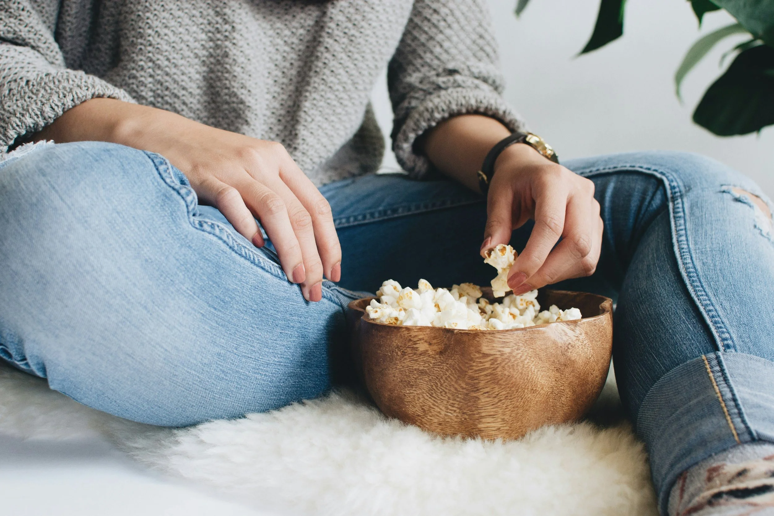 Woman eating popcorn to relax after hard day.