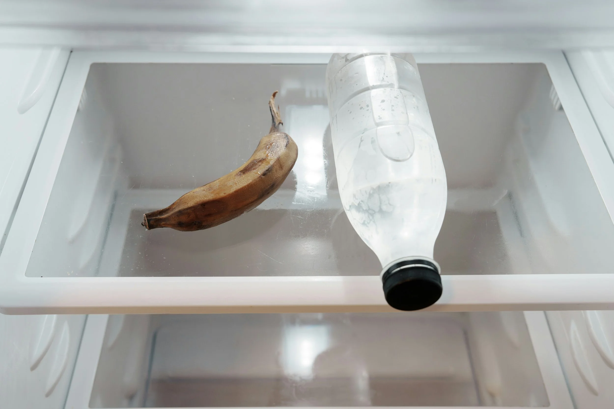 A mostly empty fridge signifying that when you constantly limit food, you will be thinking about it a lot.