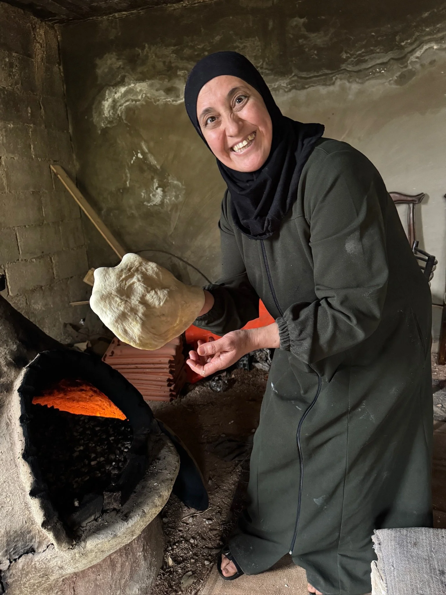 Without any tools, Reema placed the dough directly onto the hot pebbles inside the blazing oven.