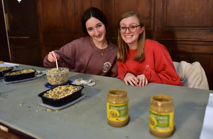 Students Faith Orzeck (left) and Katie Trzaska (right) preparing to help kids make bird feeders.