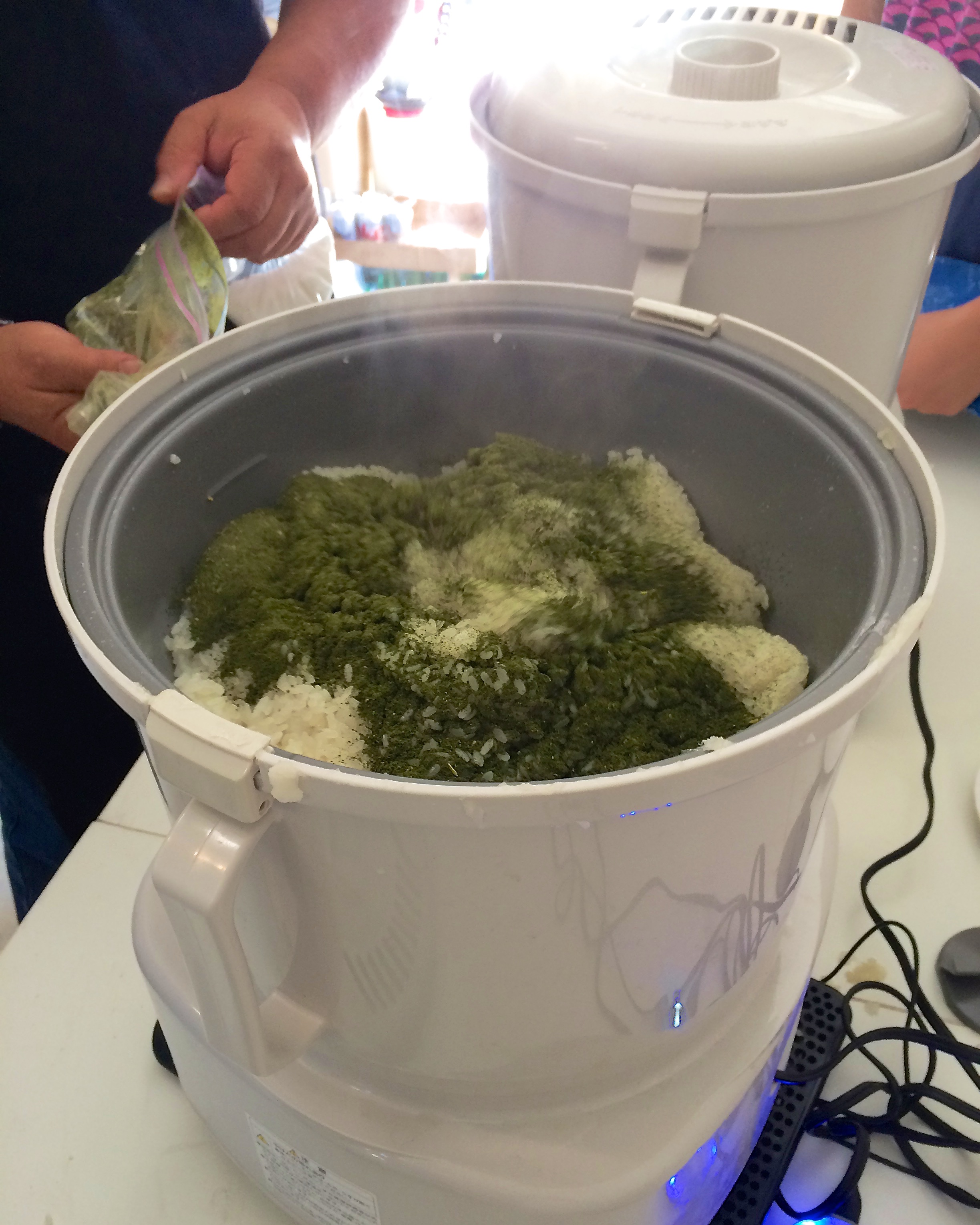 Adding green tea to the rice as it was being ground