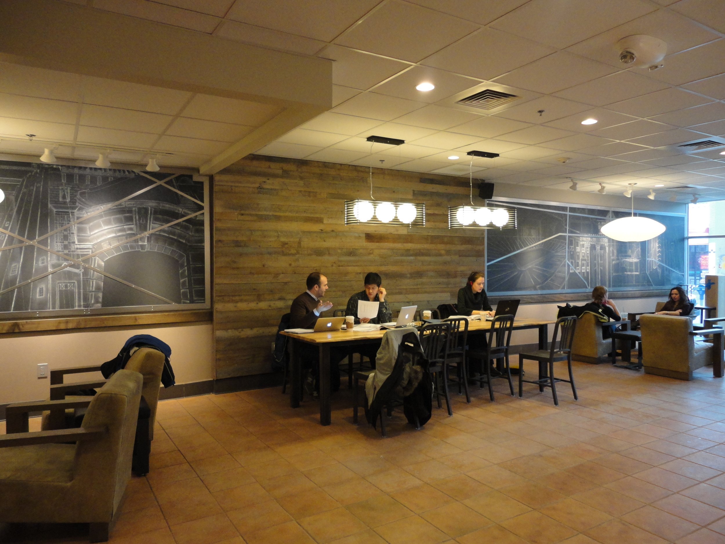  Chalk mural with steel border located at the East University Starbucks.&nbsp; The mural on the left depicts prominent campus landmarks with the overlapping steel sections creating an aerial map of the Diag.&nbsp; The mural on the right depicts popul