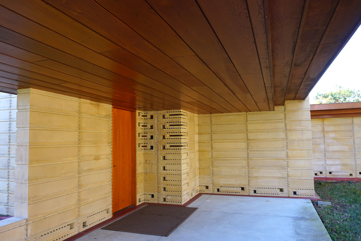 © 2019 Louise Levergneux. The exterior of the Usonian House features cypress soffit and fascia, window and door frames, pergolas, and doors.