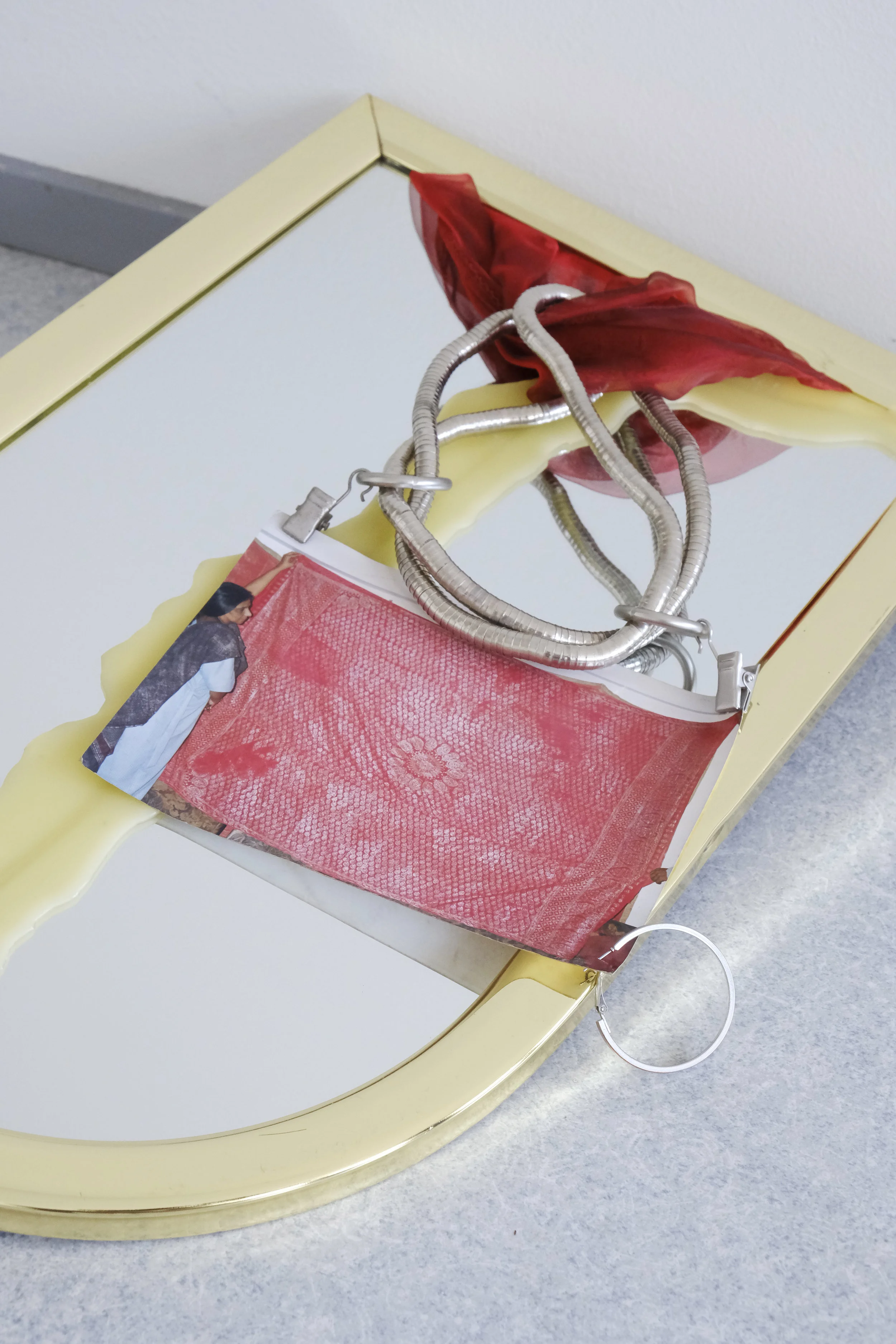 Detail of Untitled (Foundation), 2018, Dimensions Vary According to Make-Up Routine Broken Mirror, Beeswax, Costume Jewelry Necklace, Curtain Clips (2), Found Photograph from New Delhi (Women Holding Silver Thread Embroidered Tapestry), Found Fabric, Hoop Earring Left by Summer Subletter, Door Stop. Photo by Vanessa Kowalski.