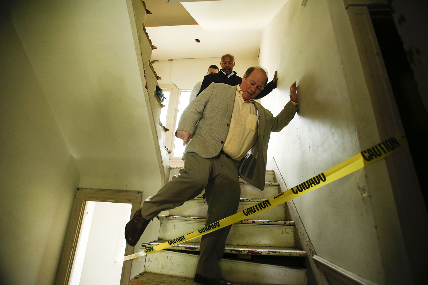 Mayor Mike Duggan steps over caution tape in a home on the Boston Edison Auction Tour on Sat., May 17, 2014 in Detroit. Many of the homes had areas restricted by caution tape and the tour required the signing of a waiver due to potentially dangerous areas in the houses. Tim Galloway/Special to DFP