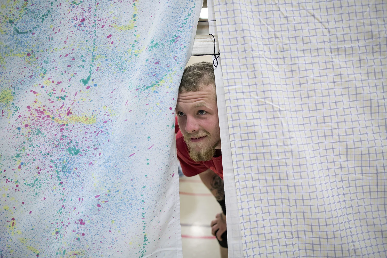 Flint, MI - Thursday, June 25, 2015: John Myers from Mt. Morris, MI peeks through the sheets draped over the net during practice at the Elmer A. Knopf Learning Center in Flint, MI. The Michigan Special Olympics Volleyball Team has been preparing for the 2015 Special Olympics Summer Games in Los Angeles, CA beginning July 25. (Tim Galloway for ESPN)
