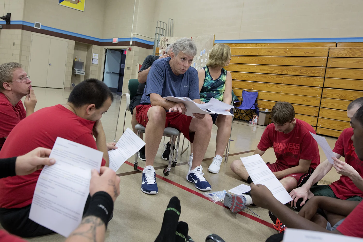Flint, MI - Thursday, June 25, 2015: Coach Sheila Gafney from Grand Blanc, MI, center, goes over paperwork for the upcoming trip to Los Angeles, CA with the team after practice at the Elmer A. Knopf Learning Center in Flint, MI. The Michigan Special Olympics Volleyball Team has been preparing for the 2015 Special Olympics Summer Games in Los Angeles, CA beginning July 25. (Tim Galloway for ESPN)