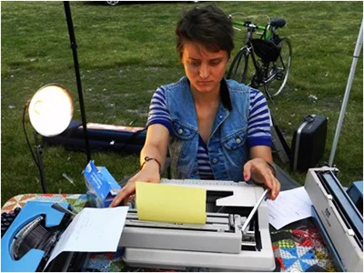 Freesia McKee, behind a typewriter, working hard at her craft.