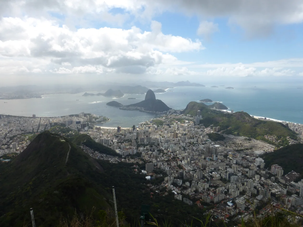 This the view from the Redeemer of Sugarloaf mountain in the distance and a section of Rio. Because of the height of the peaks surrounding it, Rio was built in the valleys in between.