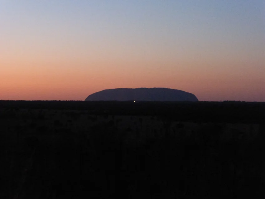 The most beautiful views of the rocks are at sunrise and sunset. This is Uluru (from a distance) at sunrise.