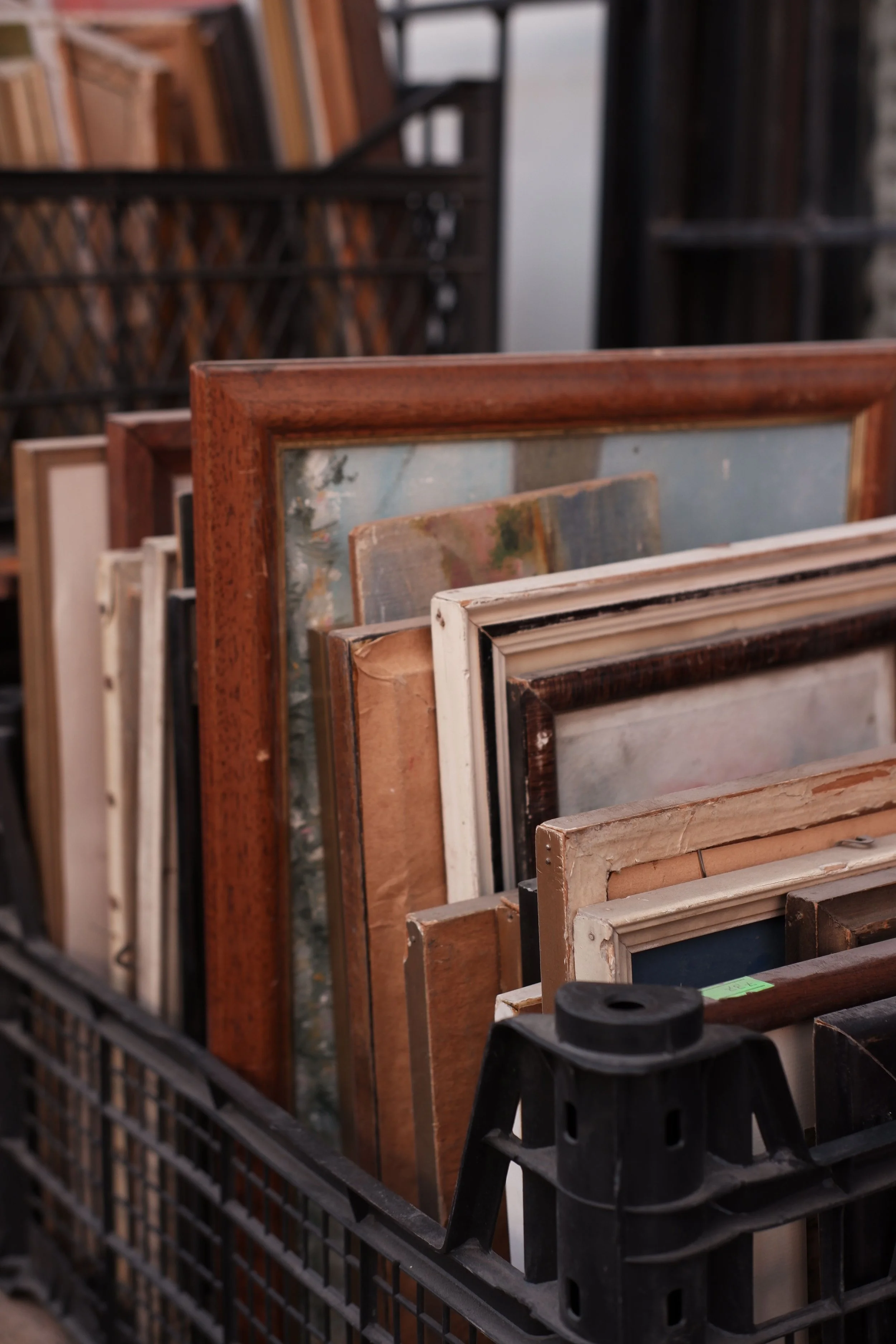 A bin containing old framed artwork