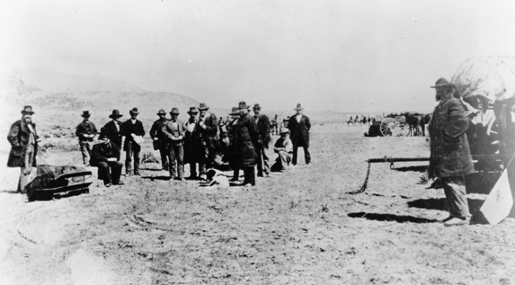 JOHN D. LEE (SEATED) AWAITING HIS EXECUTION AT MOUNTAIN MEADOWS ON MARCH 28, 1877 (SOURCE WIKIMEDIA COMMONS)