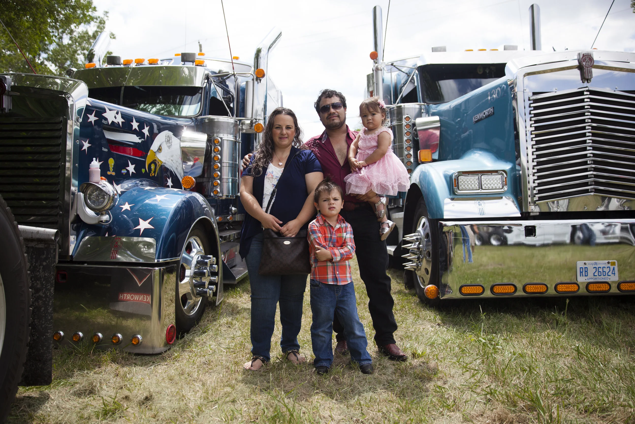 Jesus stands with his family in front of his truck after the annual Misa de Traileros (#BlessingOfTheSemis) he helps to organize. Inside his truck he shares about how the Misa de Traileros came about. (2017)