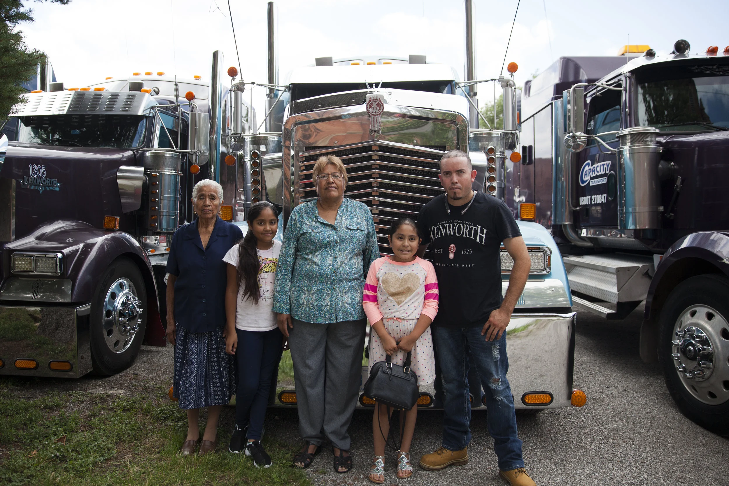 Fernando stands with friends and family in front of his truck at the annual Misa de Traileros (#BlessingOfTheSemis) at Ste Anne's in Southwest Detroit. (2017)